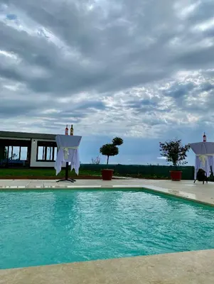 a swimming pool with blue water in front of a building at Vino & Vista in Ripanj