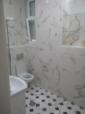 a white bathroom with a toilet and a sink at Cricket 2 Hostel in Belgrade