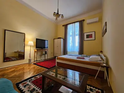 a living room with a bed and a television at Cricket 2 Hostel in Belgrade