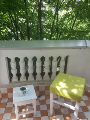 a yellow stool and a table and a fence at Cricket 2 Hostel in Belgrade