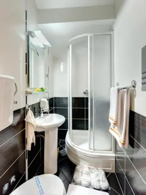 a bathroom with a shower and a toilet and a sink at Hotel Forever in Belgrade