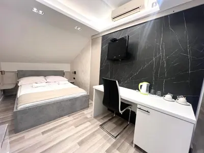 a bedroom with a bed and a desk with a computer at Hotel Forever in Belgrade