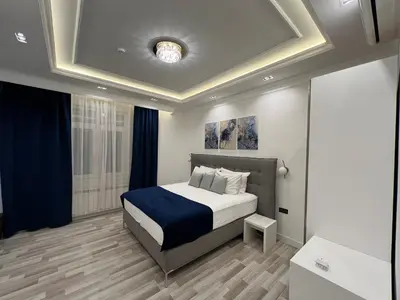 a bedroom with a bed with a blue blanket at Hotel Forever in Belgrade