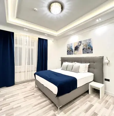 a bedroom with a large bed with a blue blanket at Hotel Forever in Belgrade