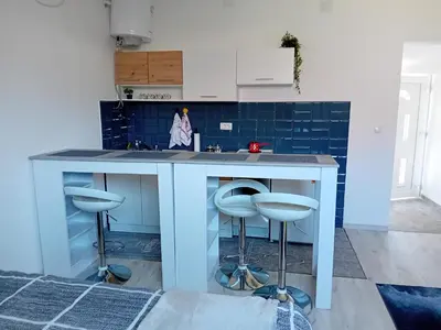 a kitchen with a blue counter and stools at ALEJA park in Železnicka Stanica Inđija Selo