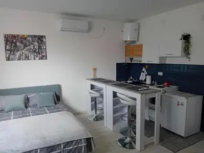 a small kitchen with a bed and a table in a room at ALEJA park in Železnicka Stanica Inđija Selo
