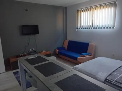 a bedroom with a bed and a blue chair at ALEJA park in Železnicka Stanica Inđija Selo