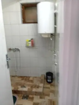 a bathroom with a shower with a wooden floor at ALEJA park in Železnicka Stanica Inđija Selo