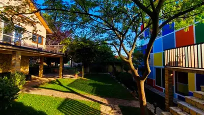 a colorful house with a tree in the yard at Muzej Accommodation in Repnica