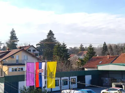 a group of flags hanging from a string in a city at Muzej Accommodation in Repnica