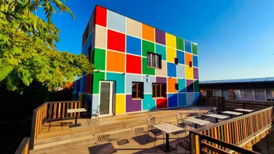 a colorful building with tables and chairs in front of it at Muzej Accommodation in Repnica