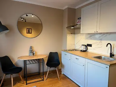 a kitchen with a table and two chairs and a sink at City Centre Apartment 3 in Belgrade