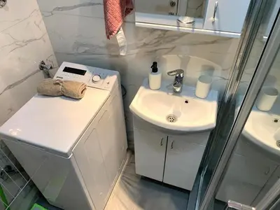 a white bathroom with a sink and a shower at City Centre Apartment 3 in Belgrade
