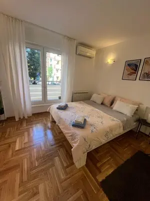 a bedroom with a bed and a large window at Manu in Belgrade