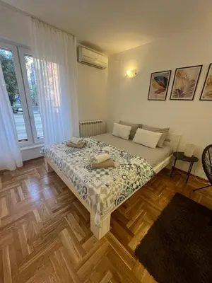 a bedroom with a bed and a large window at Manu in Belgrade