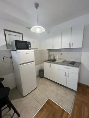a small kitchen with white cabinets and a microwave at Manu in Belgrade