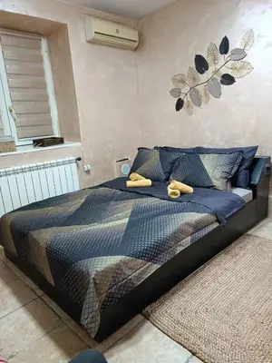 a bedroom with a bed with yellow shoes on it at Rustic central in Belgrade