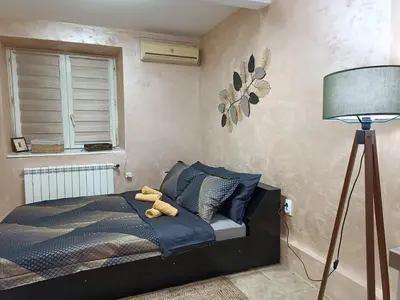 a bedroom with a bed with a stuffed animal on it at Rustic central in Belgrade