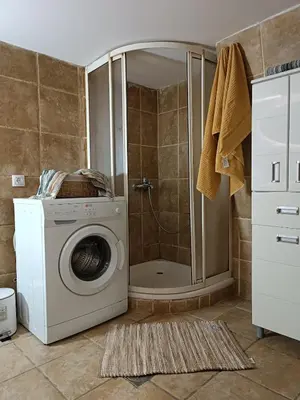 a washing machine in a bathroom with a shower at Rustic central in Belgrade