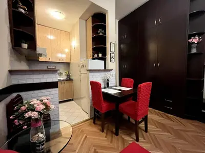 a kitchen with a dining table and red chairs at Arena view in Belgrade