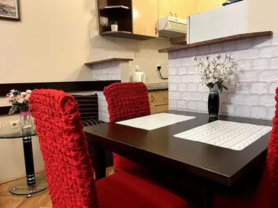 a dining room table with red chairs and a black table at Arena view in Belgrade