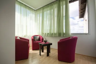 two chairs and a table in a room with a window at 12 Beds 4 Baths 2 Renovated Apts 2nd & 3rd Flr in Belgrade