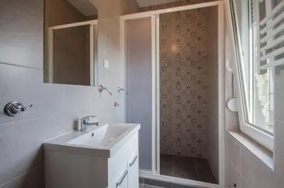 a bathroom with a sink and a shower with a mirror at 12 Beds 4 Baths 2 Renovated Apts 2nd & 3rd Flr in Belgrade