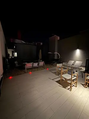 a patio with a table and chairs at night at Penthouse with River View BW in Belgrade
