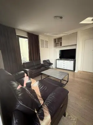 a living room with a leather couch and a coffee table at Penthouse with River View BW in Belgrade