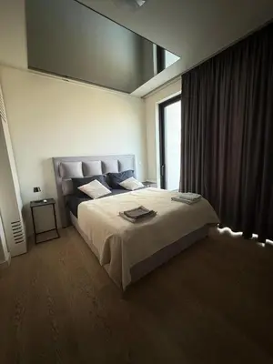 a bedroom with a large bed with a large window at Penthouse with River View BW in Belgrade