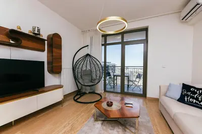 a living room with a couch and a tv at Beograd na vodi - Belgrade Waterfront Apartments in Belgrade
