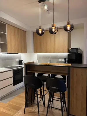a kitchen with a counter with chairs and a kitchen island at Beograd na vodi - Belgrade Waterfront Apartments in Belgrade