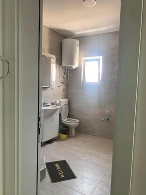 a bathroom with a toilet and a sink and a window at Appartement 2 chambres et 1 salon près de l'aéroport de Belgrade in Belgrade