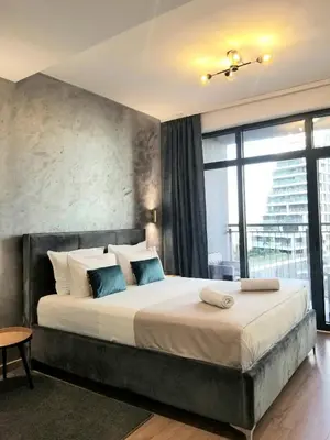 a bedroom with a large bed with a large window at Beograd na vodi - Belgrade Waterfront Iris Apartment in Belgrade