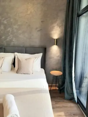a bedroom with a bed with white pillows and a window at Beograd na vodi - Belgrade Waterfront Iris Apartment in Belgrade