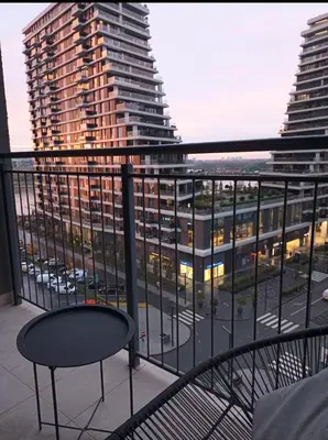 a balcony with a chair and a view of a building at Beograd na vodi - Belgrade Waterfront Iris Apartment in Belgrade