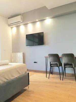 a bedroom with two chairs and a flat screen tv on the wall at Beograd na vodi - Belgrade Waterfront Iris Apartment in Belgrade