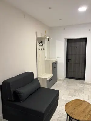 a living room with a black couch and a table at Apartman Knez Miloš in Belgrade