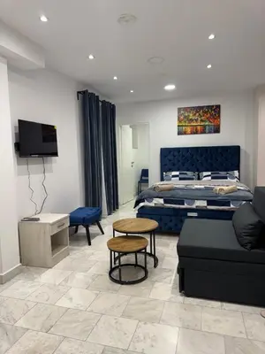 a bedroom with a bed and a couch and a table at Apartman Knez Miloš in Belgrade