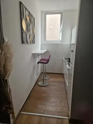 a hallway with a stool in a kitchen with a window at Relax In in Belgrade