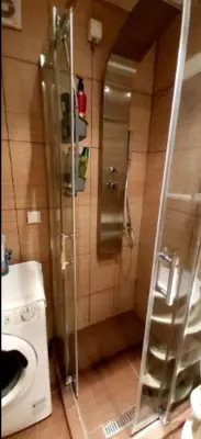 a bathroom with a shower and a washing machine at Chic apartment Dorćol in Belgrade