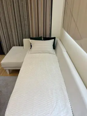 a white bed in a room with a couch at Belgrade Waterfront Lux Vista -free parking in Belgrade