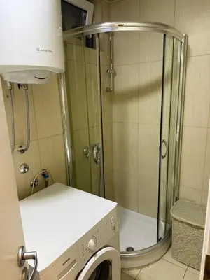a shower in a bathroom with a washing machine at Apartman Zira in Belgrade