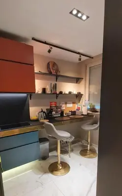 a kitchen with two white chairs and a counter at Mini Dorćolka apartment -Dorćol in Belgrade