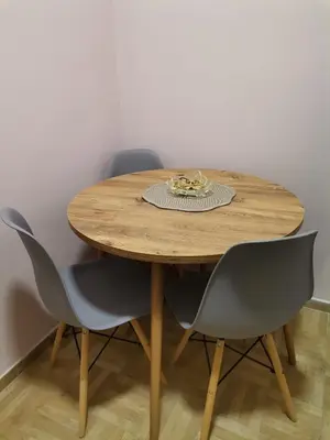 a wooden table with four chairs and a plate on it at Apartman petrov 1 in Pančevo