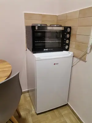 a microwave oven sitting on top of a refrigerator at Apartman petrov 1 in Pančevo