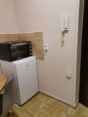 a small kitchen with a microwave and a refrigerator at Apartman petrov 1 in Pančevo