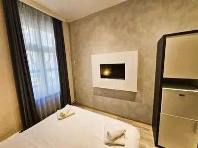 a bedroom with a bed with two towels on it at Central Park Rooms in Belgrade