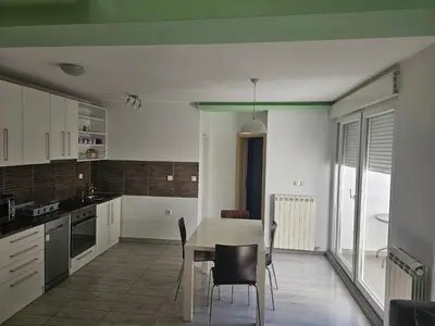 a kitchen with a table and chairs in a room at Central Park Rooms in Belgrade
