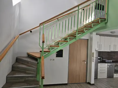 a green staircase in a room with a kitchen at Central Park Rooms in Belgrade